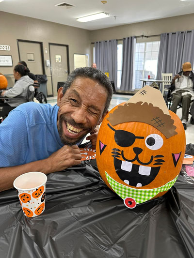 Elder Decorating Pumpkin at Lake Village Rehabilitation and Care Center
